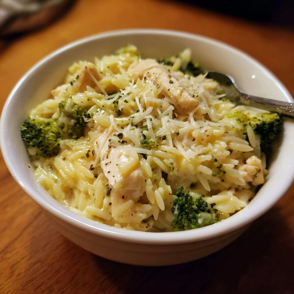 Cheesy Chicken Broccoli Orzo dish served in a bowl with fresh ingredients.