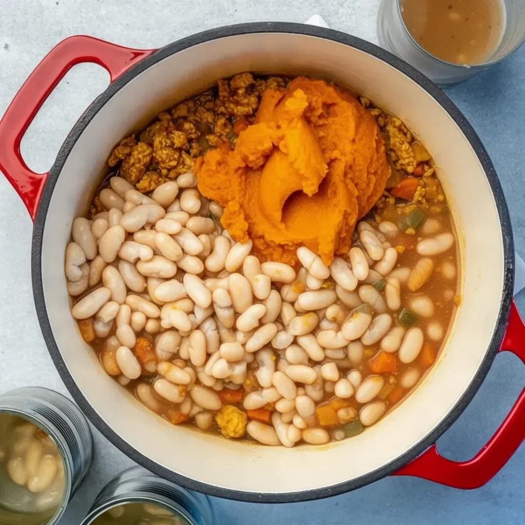 Bowl of homemade white bean pumpkin chili garnished with fresh herbs.