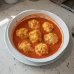 Bowl of creamy tomato soup served with cheesy cheddar bay dumplings.
