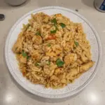 One-Pot Chicken and Orzo dish garnished with herbs in a rustic bowl