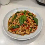 Delicious Thai Basil Chicken served with rice and fresh basil leaves