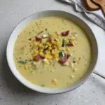 Bowl of Zucchini Corn Chowder garnished with fresh herbs